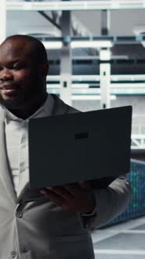 Vertical Video Technician Walks in Data Center Configuring Storage Devices for Minimal Latency