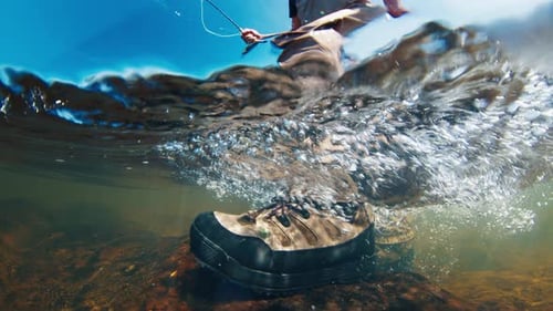 Angler Walks in the River in Wading Boots