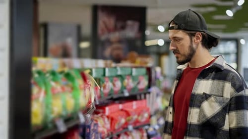 Young Man Shopping in Supermarket Aisle