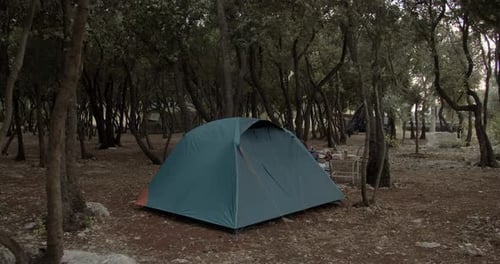 Tent in forest campsite, wide shot. medium shot