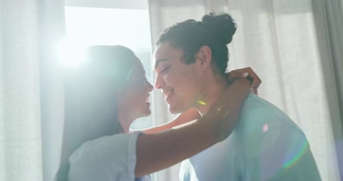 Couple Embraces and Kisses in Bright Sunlight