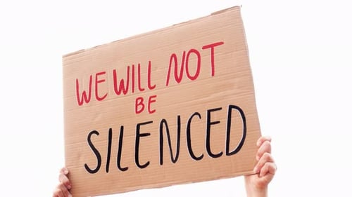 People protest for change holding "We will not be silenced" banner on the road - Demonstrator
