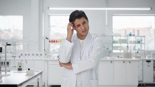 Man in Lab Coat Thinking in Bright Laboratory