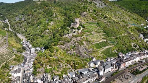 Aerial footage of Gutenfels Castle among vineyards on steep slopes and Kaub, historic town with tra