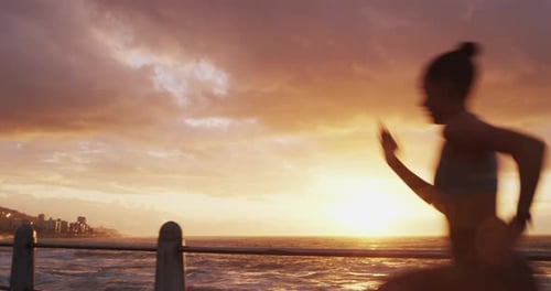 Woman Runs Beside the Ocean at Sunset