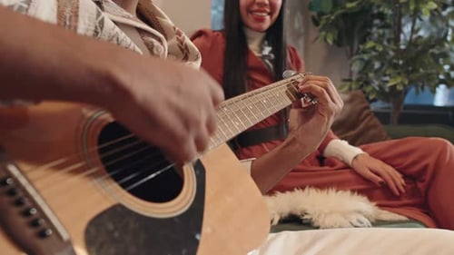 Close Up of Guitar Player with Smiling Listener