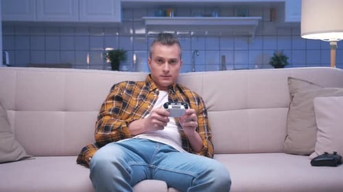 Man Playing Video Game on Couch at Home