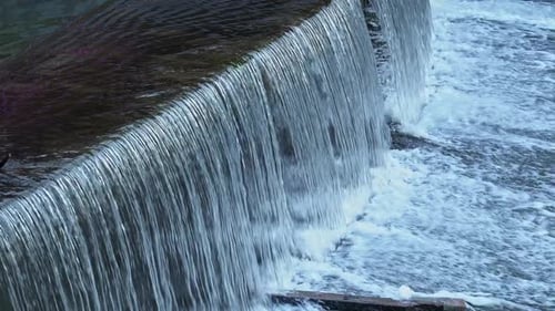 Water Cascades Beautifully Over Dam Showcasing Nature's Art in Motion