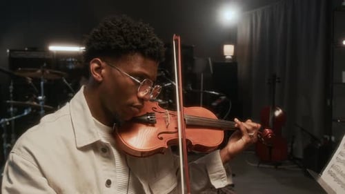 Young Adult Man Plays Violin in Music Studio