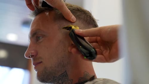 Close Up of Barber Cutting Man's Hair in Salon