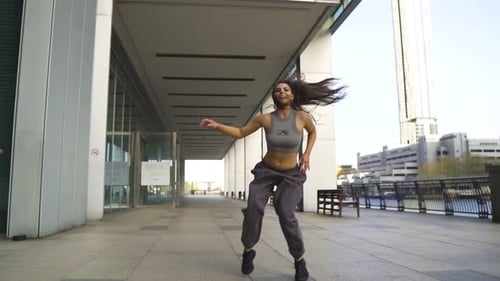Energetic young gorgeous caucasian female hip hop street dancer performing in a city slow motion bri