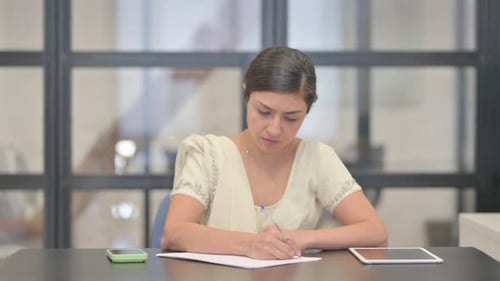 Young Indian Woman Writing a Letter in Office