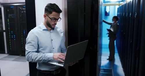 Colleagues working in a server room with computers