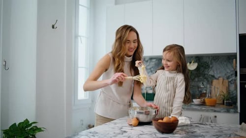 Mother and Daughter Baking Together in Kitchen