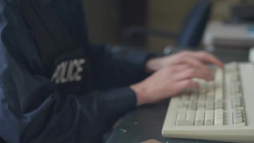 Police officer - close up of hands on keyboard writing report HD