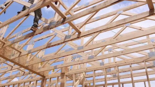 Construction Worker Builds Wooden Structure Under Works Day with Scattered