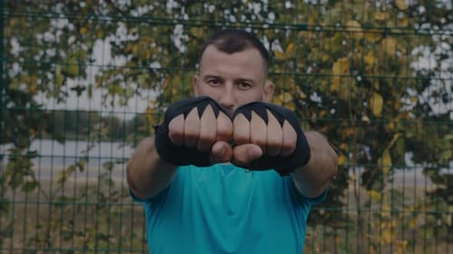 Young Man Performing Boxing Exercise Outside