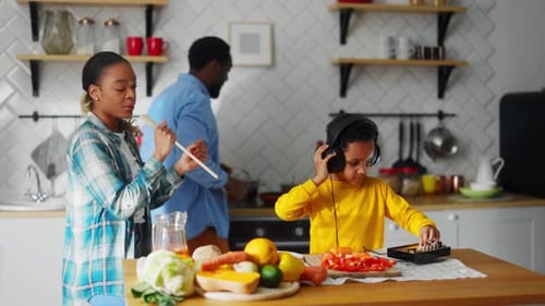Family Dances and Cooks Together in Kitchen
