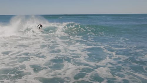 Slowmotion view of male surfer riding the perfect blue ocean wave