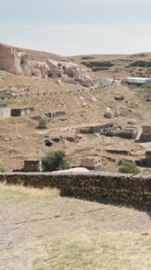 Une jeune femme se promène dans l'ancienne ville de Saratli, en Turquie, avec une tête suspendue. Vidéo verticale