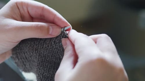 Close Up of Hands Knitting Brown Wool Fabric
