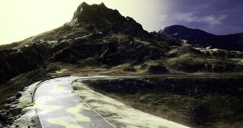 Winding Road Through Dramatic Mountain Landscape at Golden Hour Glow