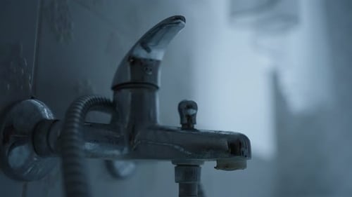 De l'eau s'écoule du robinet qui fuit dans la salle de bain
