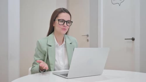 Woman Video Calling on Laptop in Office