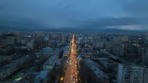 Wide street with tall buildings and mountains in Bishkek