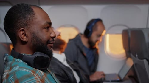 Man Puts On Headphones on Airplane Flight
