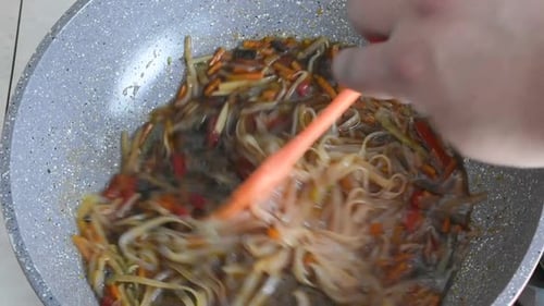 Stir Frying Noodles and Vegetables in Pan