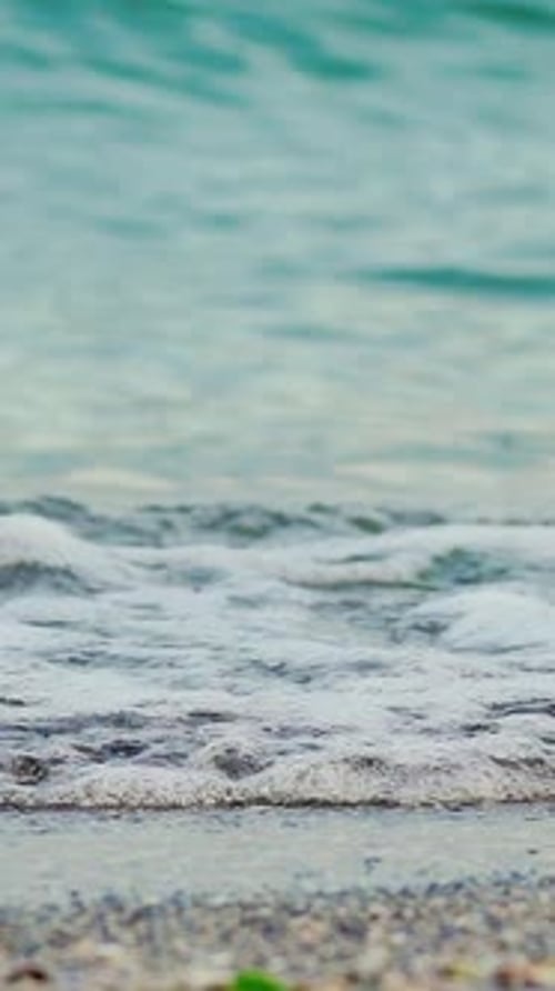Wave of the sea on the sand beach. Big sea wave. Slow motion Vertical video