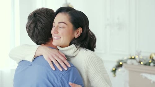 Close up Happy couple hugging while standing in living room at home during winter New Year Christmas