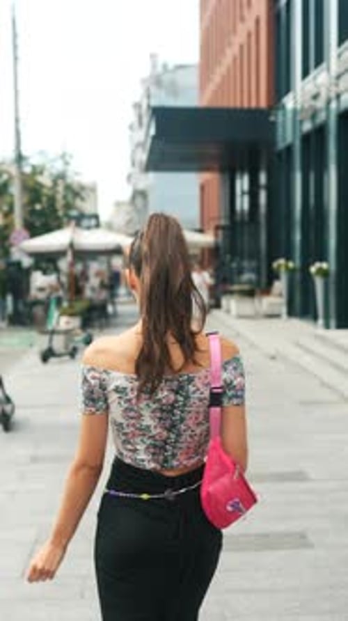 The Camera Captures the Back of a Young and Attractive Girl Rushing Through the City Streets