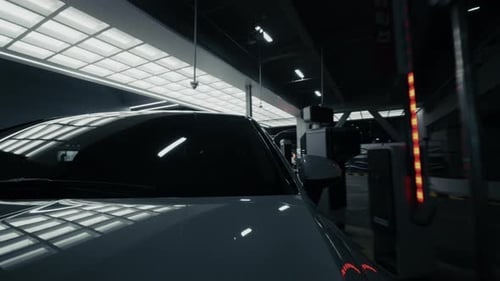 Filmmusik Fahrt in der modernen Tiefgarage mit eleganter Beleuchtung und Reflexionen auf dem Auto