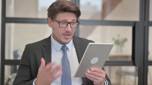 Man in Suit Using Tablet for Video Call