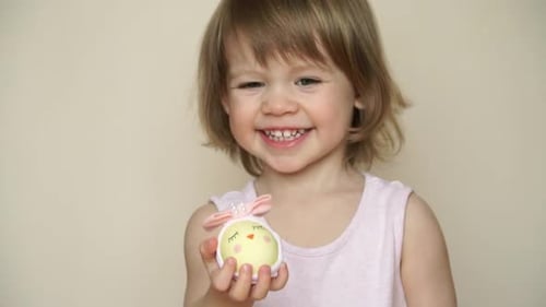 Happy Little Girl Hold Oster-Hähnchenei, dekoriert für Küken