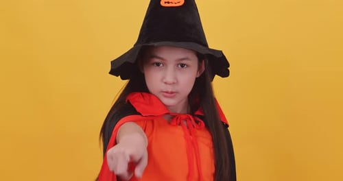 Young Girl Dressed as a Witch Points at Camera