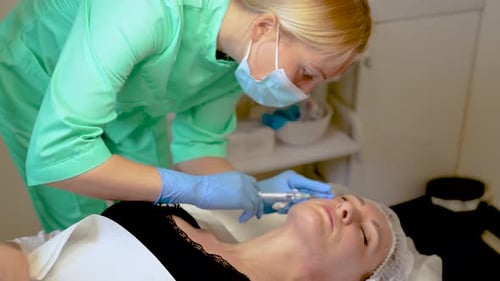 Kosmetikerin, die dem Kunden Neurotoxin injiziert, Verjüngungsverfahren, Mesotherapie