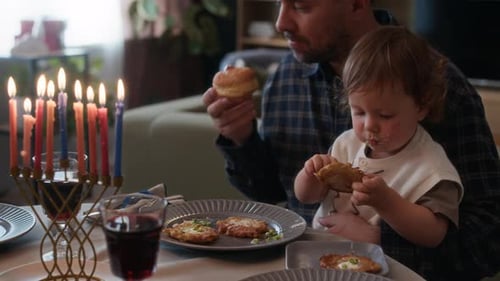 Family Celebrates Hanukkah with Candles, Food, and Tradition