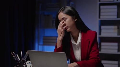 Businesswoman seriously stressed working overtime headache and eye ache due to office syndrome