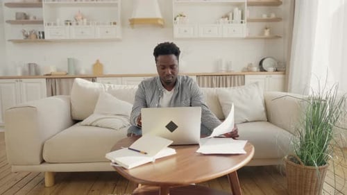 Man Works On Laptop At Home
