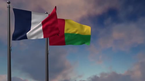 Flags of France and Guinea-Bissau Waving Against Blue Sky