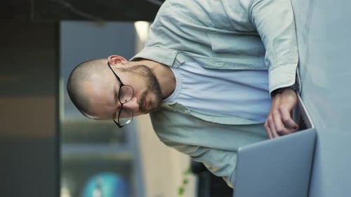 Smiling Businessman Working on Laptop Computer at Home Office