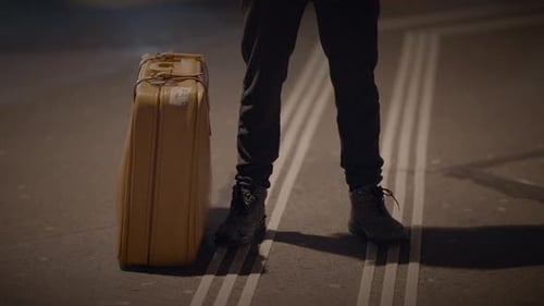Young Adult with Suitcase Standing on Urban Street
