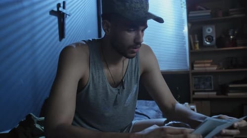 Man Looks at Photos in Dark Room