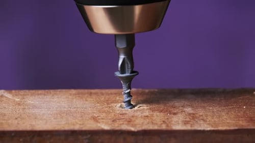 CloseUp of Unscrewing the Screw From a Block of Wood With a Screwdriver