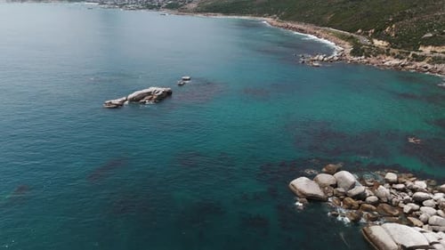 Drohnenclip des türkisfarbenen Ozeans mit Bergkette im Hintergrund