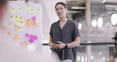 Young Woman Leading Brainstorming Session at Office