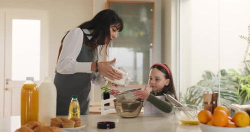 Woman and Girl Bake Together in Home Kitchen
